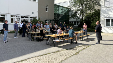 Heurigenbänke sind vor einem Haus aufgestellt. Leute essen.