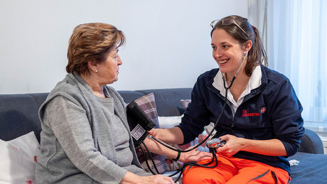 Eine Johanniterin misst den Blutdruck einer Patientin.