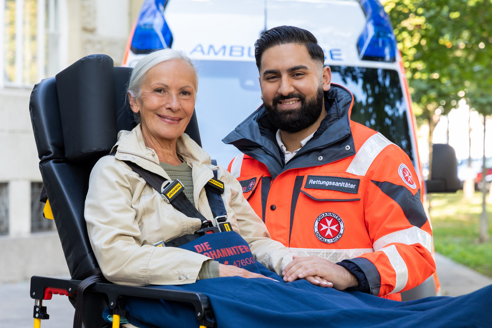 Eine Patientin auf einer Fahrtrage und ein Zivildienstleistender, der ihre Hand hält