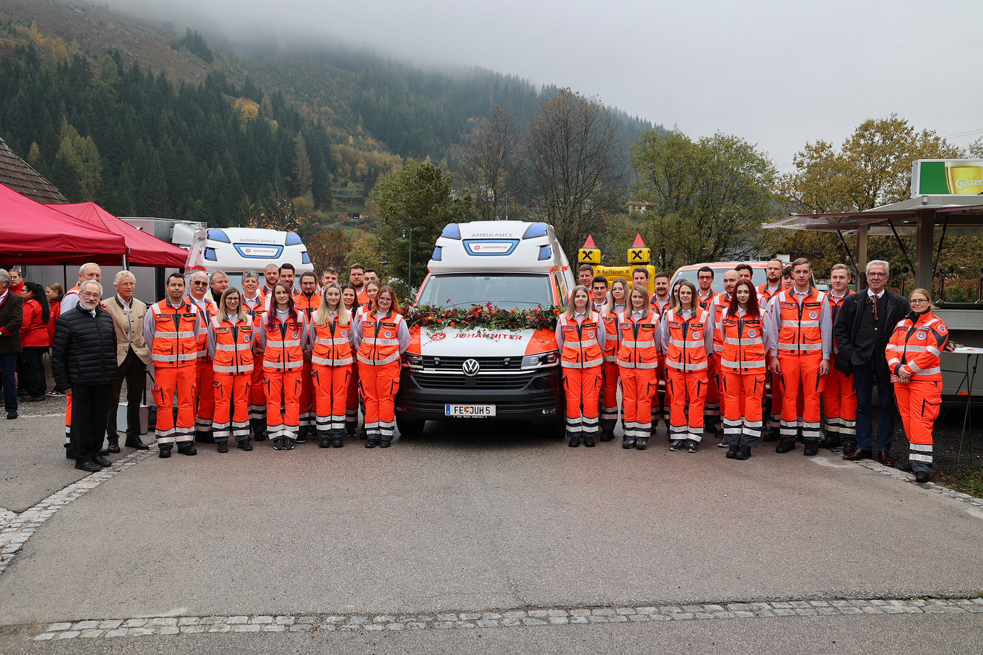 Gruppenfoto der Johanniter Kärnten mit dem neuen Krankentransportwagen