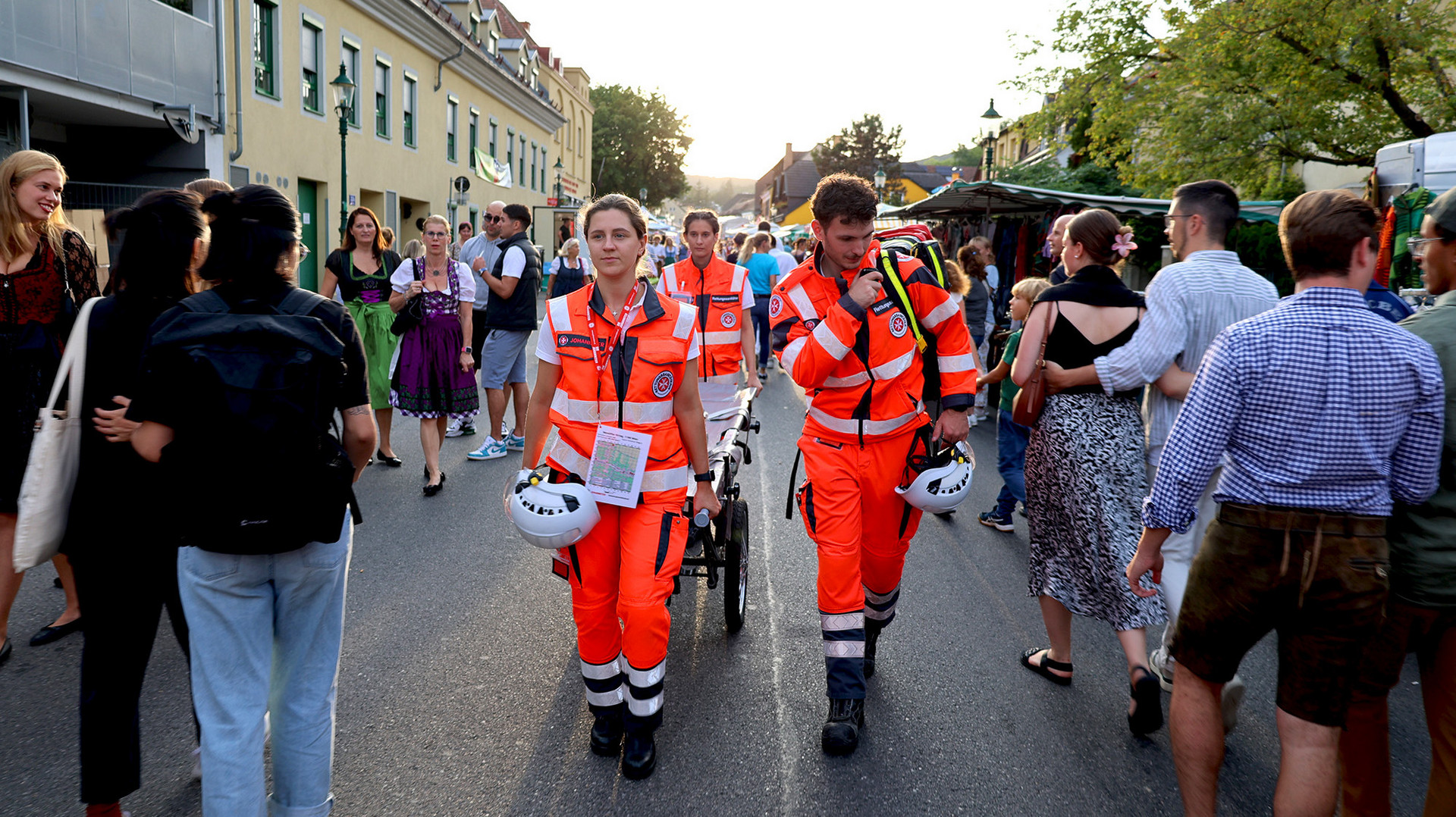 Ein Sanitätsteam geht durch die Menge beim Kirtag.